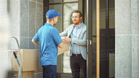 Delivery Man Gives Postal Package To A Business Customer In Stylish