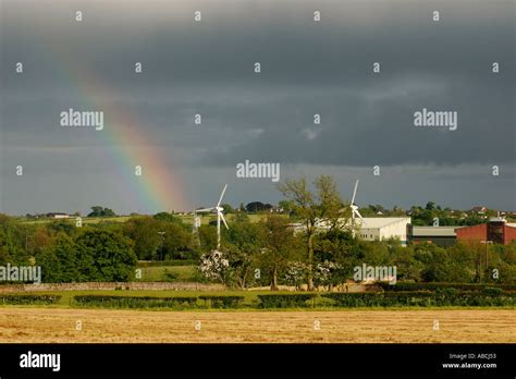 Wind Turbines And Brooding Sky With Rainbow Next To The Gsk Factory In