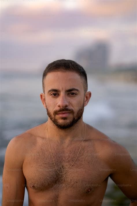 A Shirtless Man Standing In Front Of The Ocean Photo Male Model Image