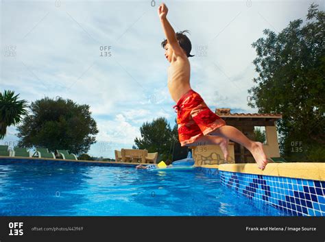 Young Boy Jumping Into Swimming Pool Stock Photo Offset