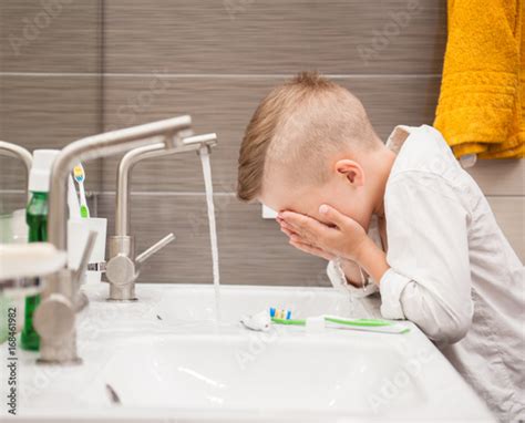 Boy Is Washing His Face In The Bathroom Stock Photo Adobe Stock