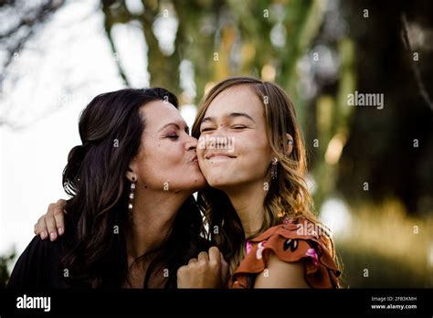 Madre Besando Hija Adolescente En Desert Garden En San Diego Fotografía