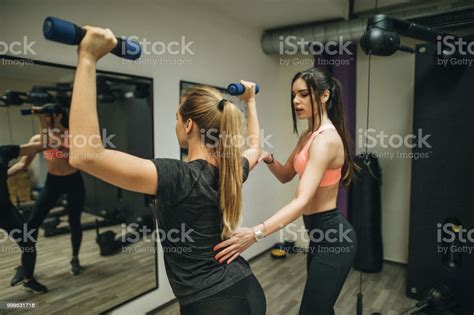 Sporty Girl Doing Weight Exercises With Assistance Of Personal Trainer