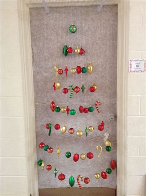 A Christmas Tree Made Out Of Ornaments On The Door Way To A Room With White Walls