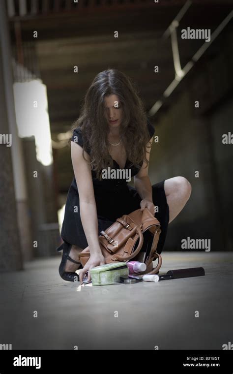Young Woman Picking Up Spilled Personal Items From The Floor Stock