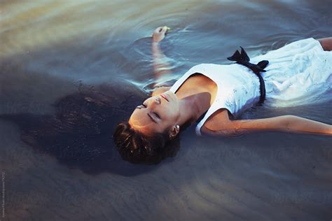 Beautiful Young Girl Laying In Water Relaxing By Jovana Rikalo