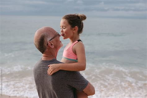 Active Happy Grandpa Having Fun With Granddaughter On Beach Vac By Stocksy Contributor Rob