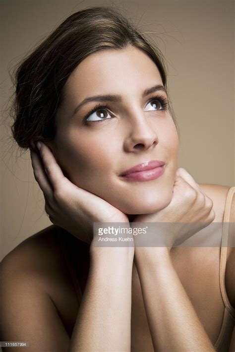 Young Woman Resting Her Chin On Hands While Looking Up Smiling Woman