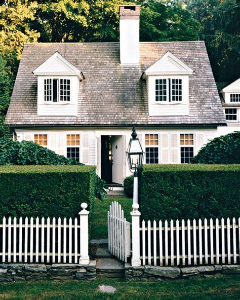 A White House Surrounded By Hedges And Trees