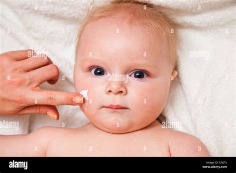 Infant Creaming Face On White Towel Stock Photo Alamy