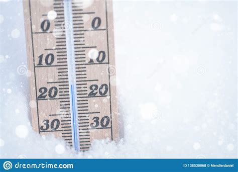 Wooden Thermometer With Falling Snow In Snow With Freezing Temperature