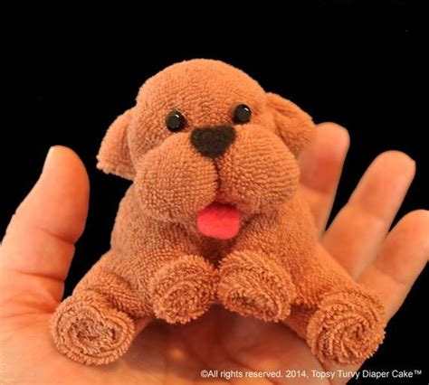 A Hand Holding A Small Stuffed Dog In Its Right Hand With Its Tongue
