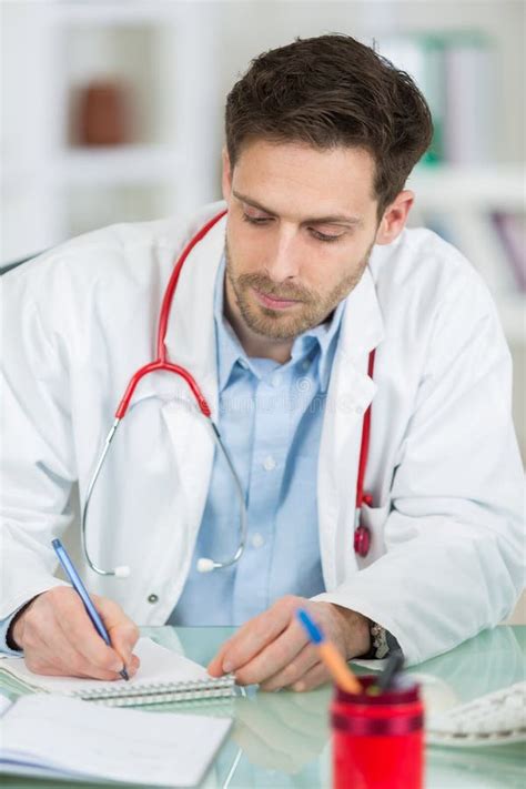 Male Doctor Writing Prescription At Desk Stock Photo Image Of Care