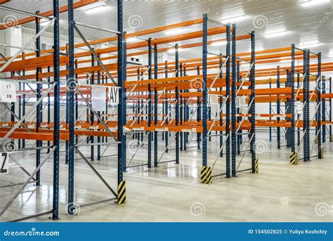 Empty Orange Warehouse Shelves In Grey Industrial Interior Stock Image