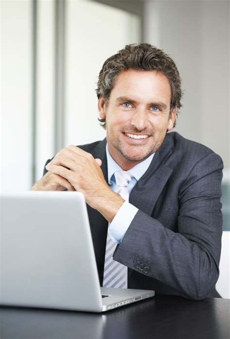 Portrait Of Business Man Using Laptop And Giving You A Warm Smile Kgr