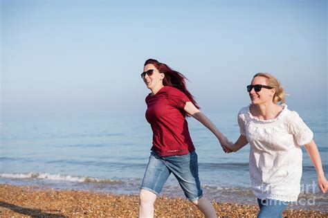 Lesbian Couple Holding Hands On Beach Photograph By Caia Imagescience