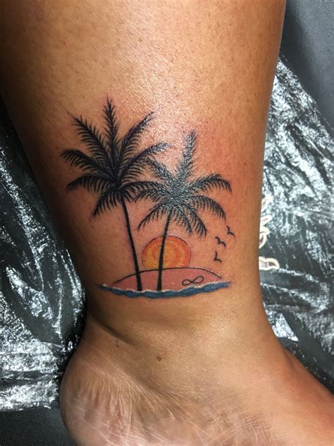 A minimalist palm tree tattoo on the arm with a sunset. Palm Tree Tattoo with a beautiful sunset on a beach ...