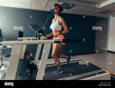 Female Runner With Mask Running On Treadmill Machine Testing Her Performance Woman Athlete