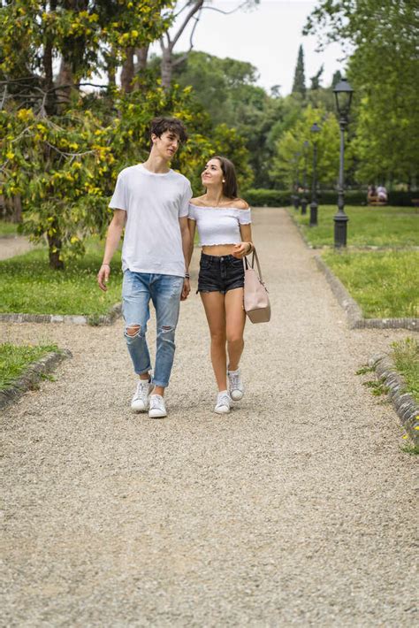 Young Couple Walking Together In A Park Stockfoto