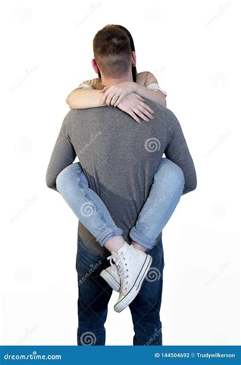 pares juguetones con la mujer joven envuelta alrededor de la cintura del novio aislada en blanco