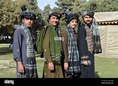 people in traditional pashtun dresses pose for photos during a ceremony marking pashtun cultural