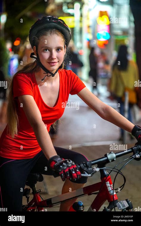city night bicycle ride girls wearing bicycle helmet nightlife and passer people in city