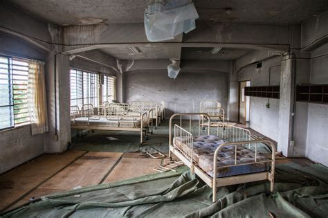 An Old Hospital Room With Beds And Sheets On The Floor