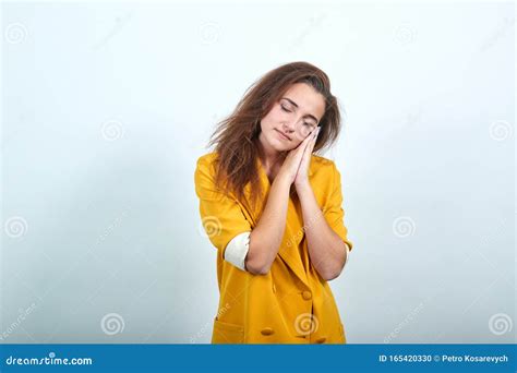 Sleepy Woman In Yellow Jacket Keeping Hand On Head Sleeping Gesture