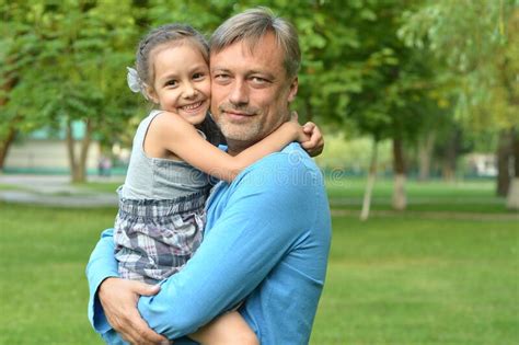 Portrait Of Happy Father And Daughter Hugging Outdoors Stock Photo