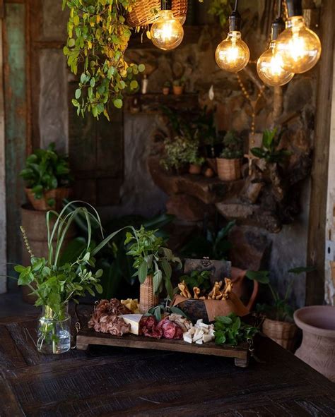 A Wooden Table Topped With Lots Of Plants And Lights Hanging From It S