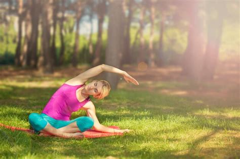 Garota fazendo yoga ao ar livre na floresta suporta um estilo de vida saudável Foto Premium