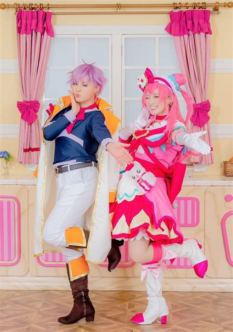 Two People Dressed In Costumes Standing Next To Each Other With Pink