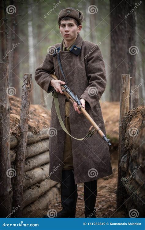A Soldier Of World War Ii Is Standing In The Trench With A Rifle In
