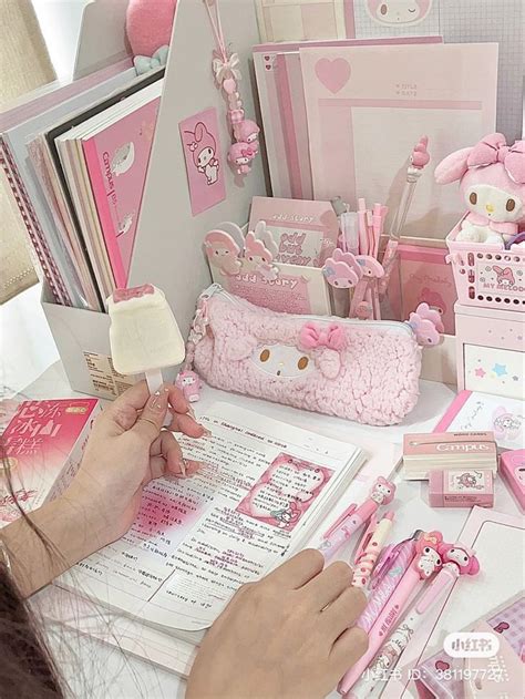 A Woman Is Writing In A Notebook Surrounded By Hello Kitty Decorations