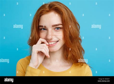 headshot portrait of happy ginger red hair girl with freckles smiling looking at camera pastel
