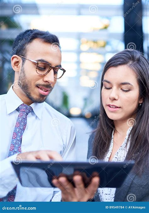 Mixed Race Couple Of Co Workers Reviewing Social Media Strategy With A