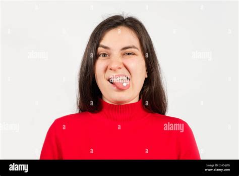 A Woman In A Red Sweater With A White Pill On Her Tongue With Her Mouth Open Writhes A