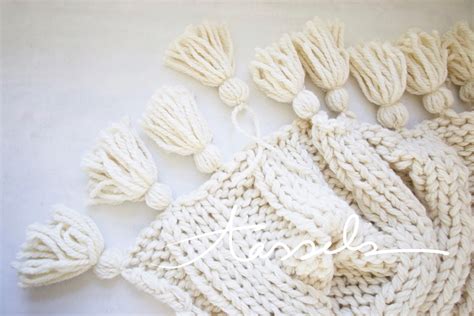 A Knitted White Scarf With Tassels And The Word Love Written On It