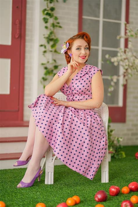 Beautiful Redheaded Pin Up Girl In Pink Polka Dot Dress And Vintage
