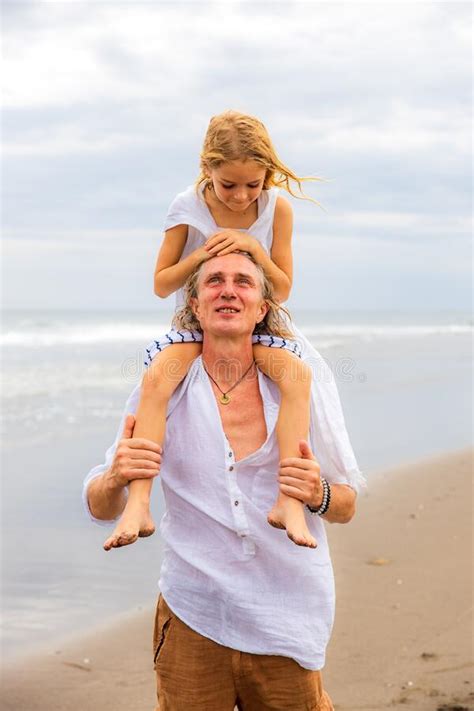 Daughter Sitting On Father`s Shoulders Father And Daughter Playing Together At The Beach Happy