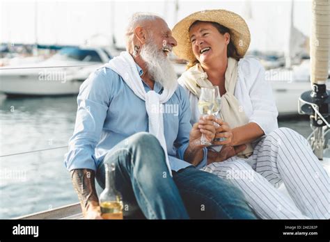 Senior Couple Toasting Champagne On Sailboat Vacation Happy Elderly