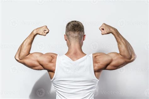homem jovem fisiculturista mostrando seus braços musculosos 16234256 foto de stock no vecteezy