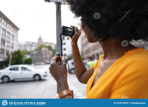 Smiling African American Woman Using Professional Camera At A Street
