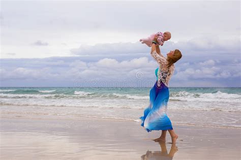Mother Holding Her Baby On The Beach Stock Photo Image Of Raised