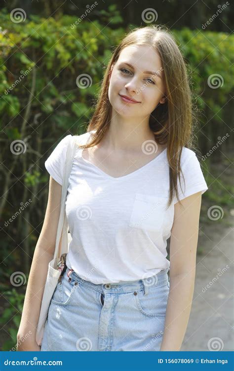 Portrait Of Beautifulblonde Teenage Girl Walking In The Park Smiling