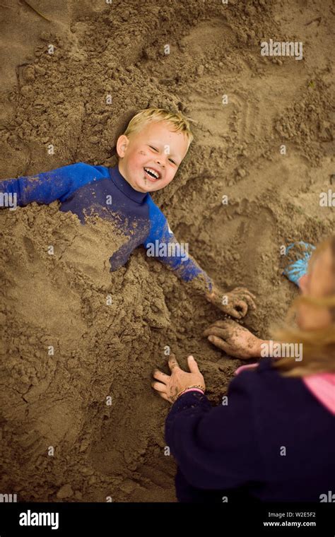 Happy Children Buried In Sand Hi Res Stock Photography And Images Alamy