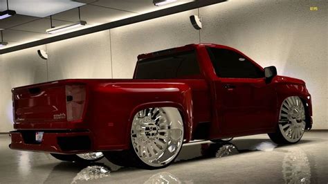 A Red Pick Up Truck With Chrome Rims Parked In A Garage Next To A White