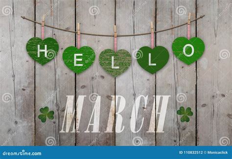 Hello March Written On Hanging Green Hearts And Weathered Wooden