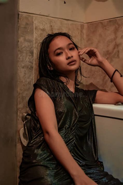 Hot And Wet Asian Girl Poses With Sensual Style While Wearing Black Wet Dresses Stock Image
