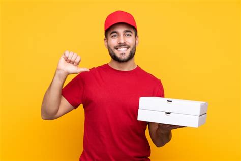repartidor de pizza con uniforme de trabajo recogiendo cajas de pizza sobre amarillo aislado